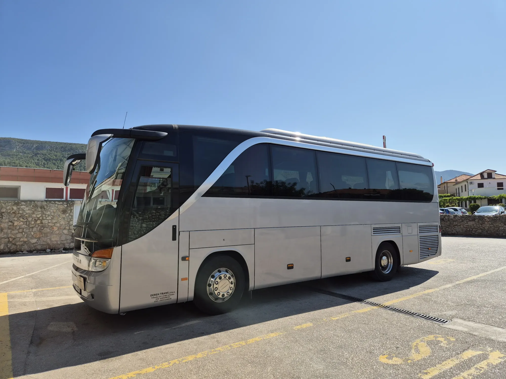 Side view of a large silver group coach parked on Hvar for big group transfers